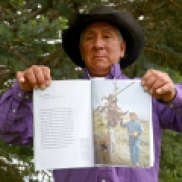A local member of the Shoshone Bannock tribe holds up a National Geographic article he was featured in.